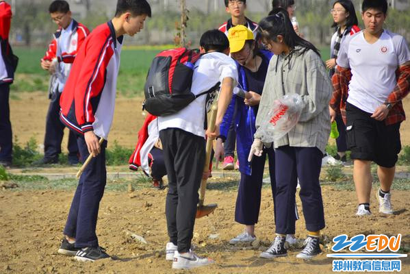 老师指导学生耕种