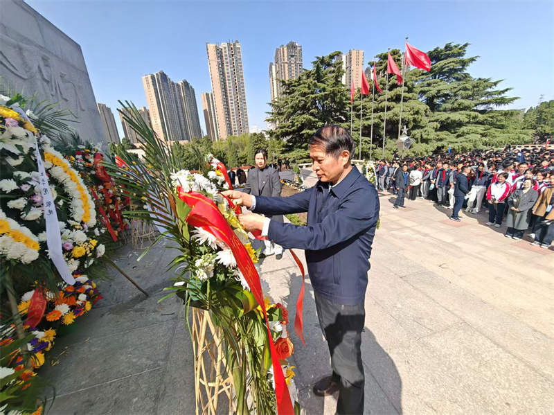 2学校纪委书记陈建兴为花篮整理缎带.jpg