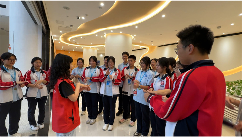 同学们跟随志愿者老师学习简单的手语.jpg