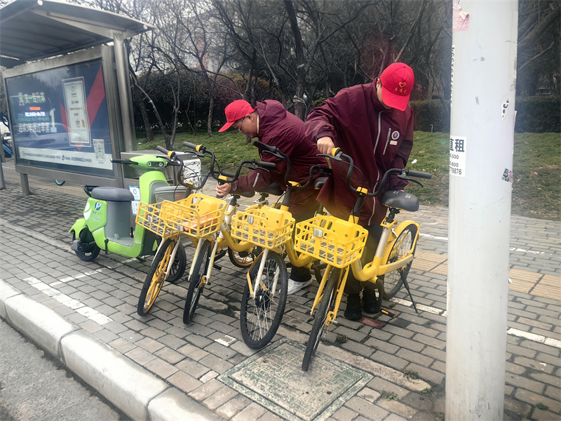 志愿者们在黄河迎宾馆站地铁口摆放共享单车.jpg